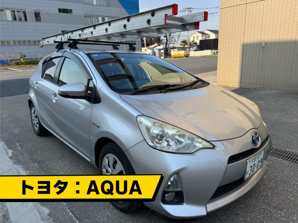 丸山建設株式会社の営業車、トヨタのアクアが住宅前に停車している様子