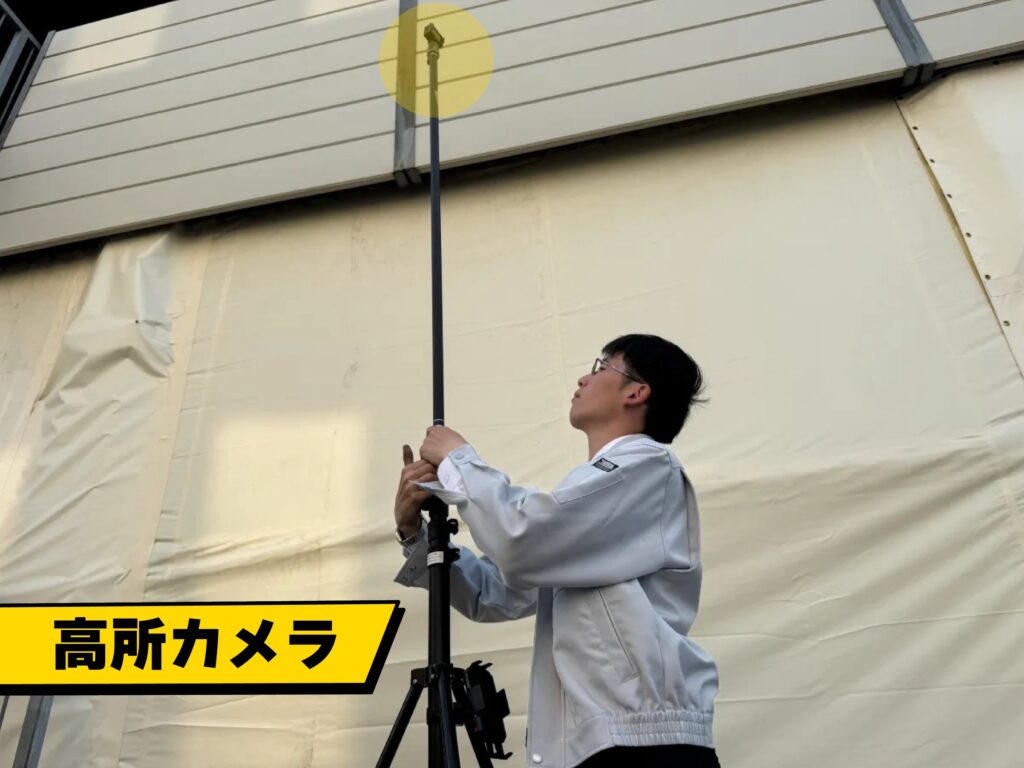 丸山建設株式会社が高所カメラを使い、屋根の高い位置を地上から撮影している様子