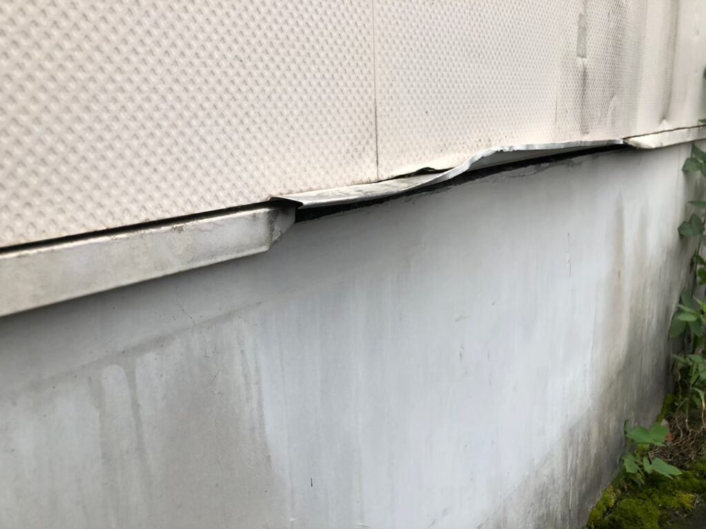 突発的な衝撃により土台水切りが大きく歪んでいる状態