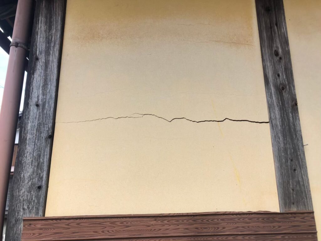 地震の影響により外壁表面にひび割れが発生し、防水性能が低下している状態