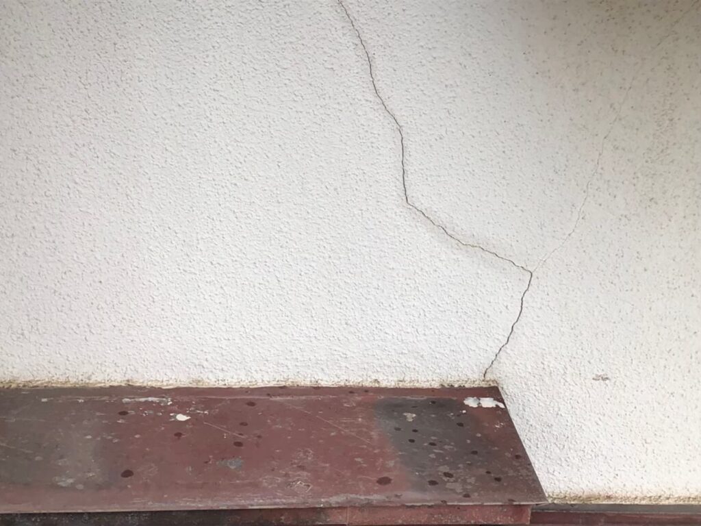 地震の影響により外壁表面にひび割れが発生し、防水性能が低下している状態