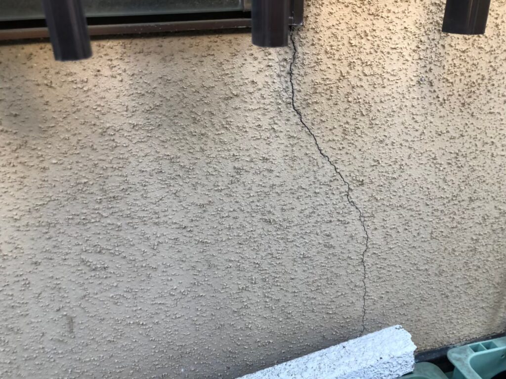地震の影響により外壁表面にひび割れが発生し、防水性能が低下している状態