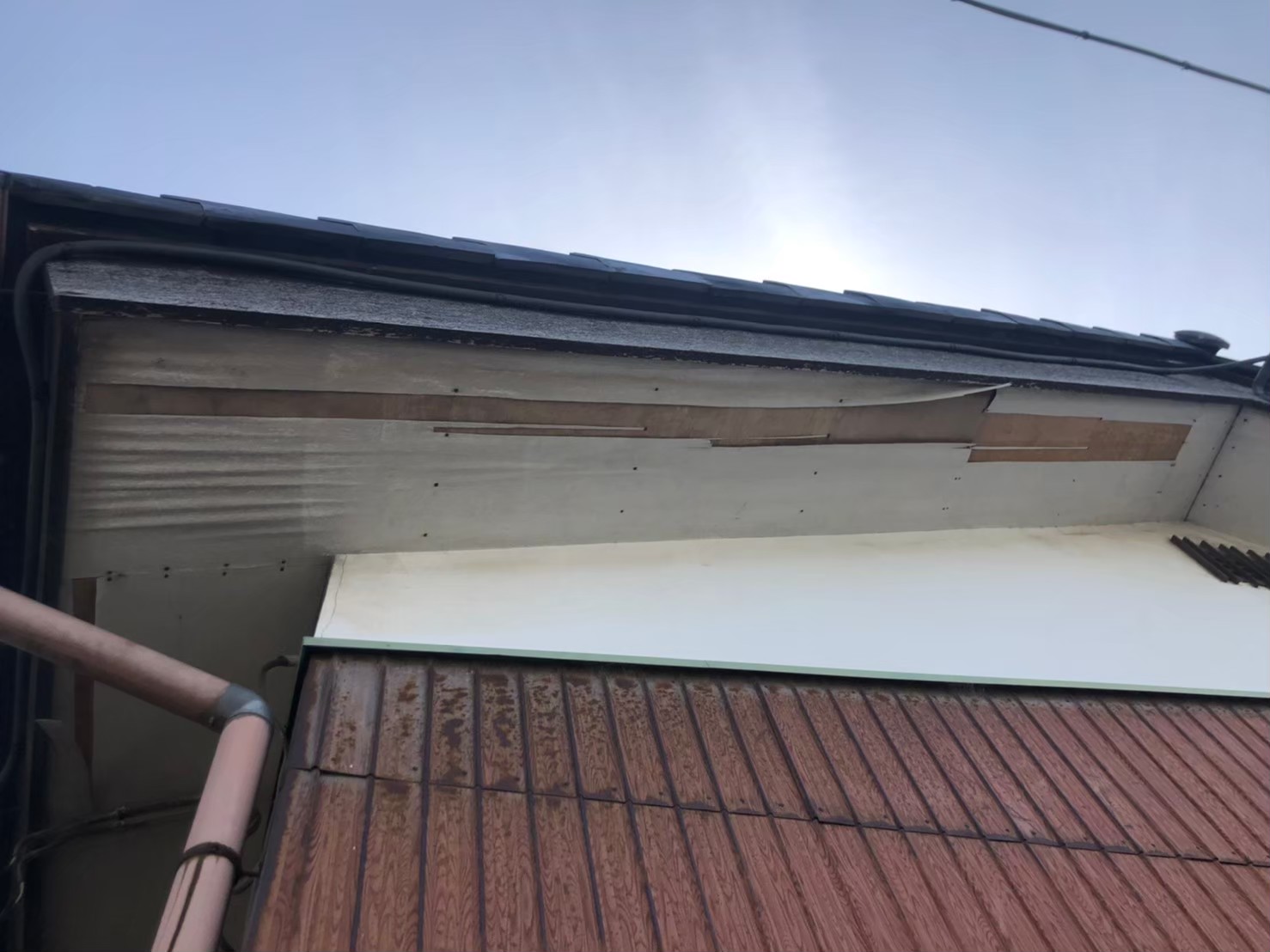 湿気や雨水の影響で軒天が腐食し、剥がれが発生している状態