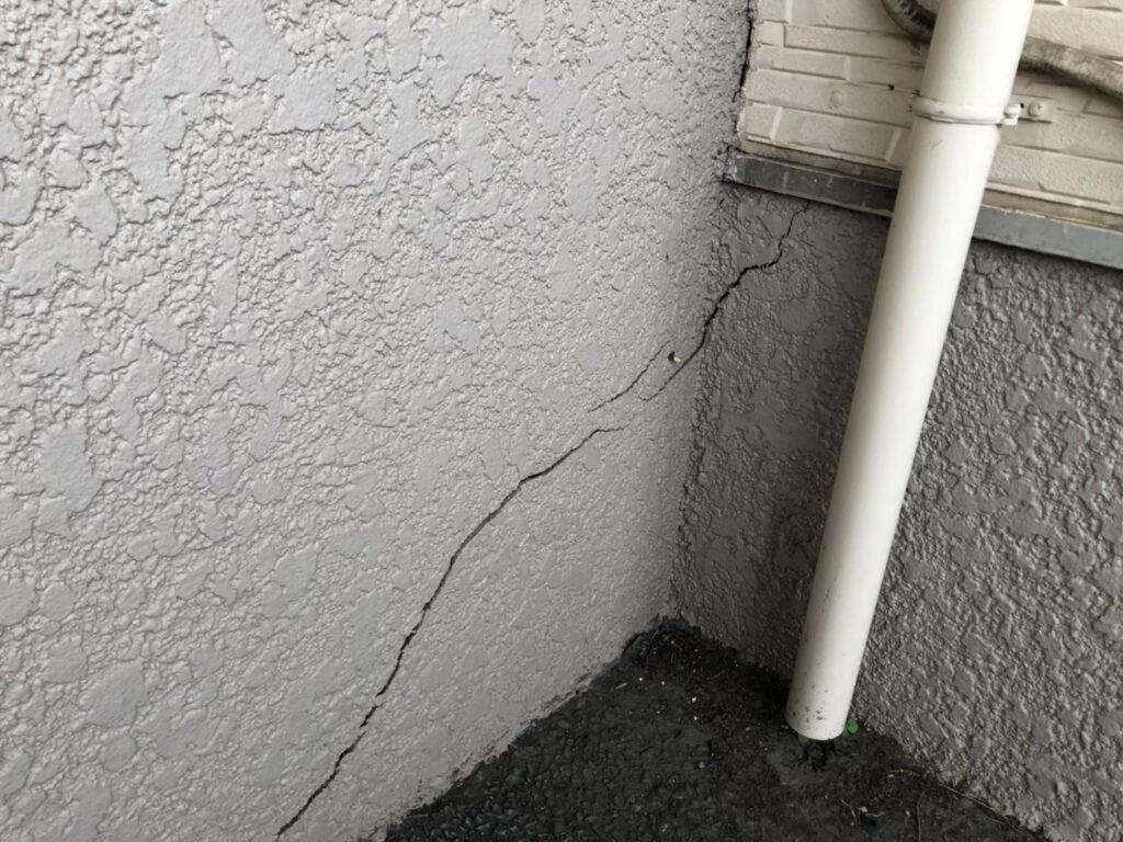 大きなひび割れが生じ雨水が侵入しやすい外壁の劣化状態