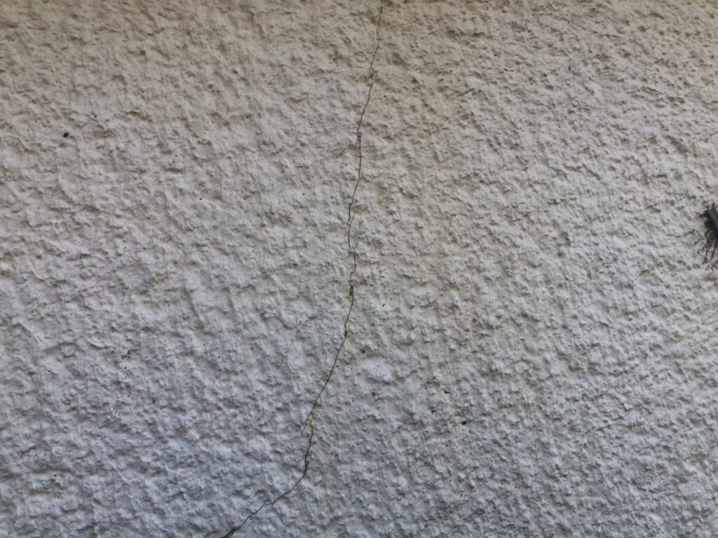 地震の影響により外壁表面にひび割れが発生し、防水性能が低下している状態