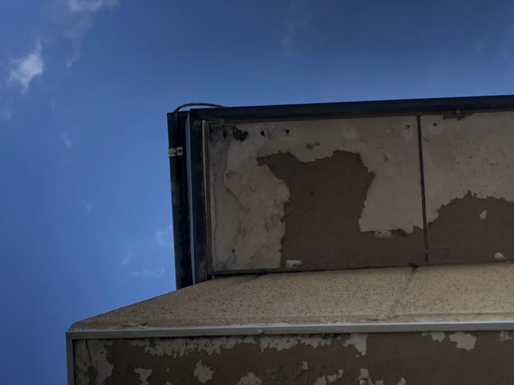 湿気や雨水の影響で軒天が腐食し、剥がれが発生している状態