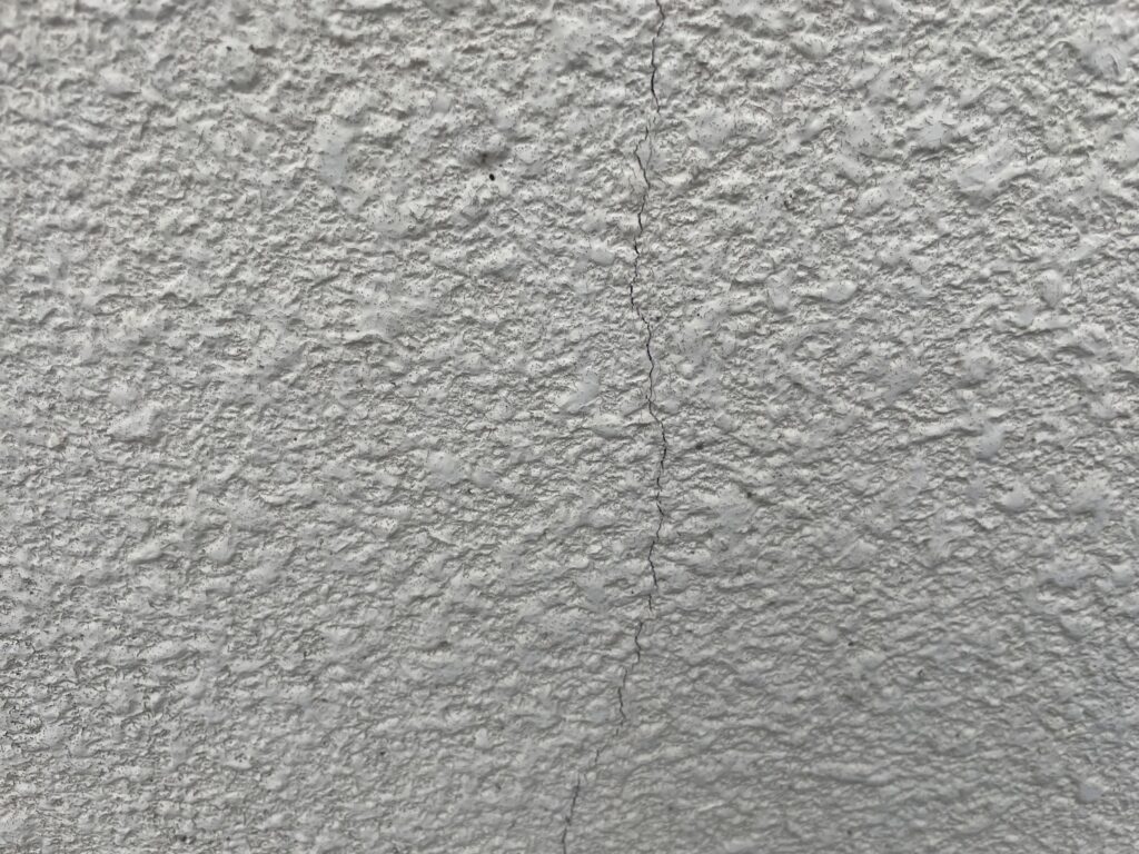 地震の影響により外壁表面にひび割れが発生し、防水性能が低下している状態