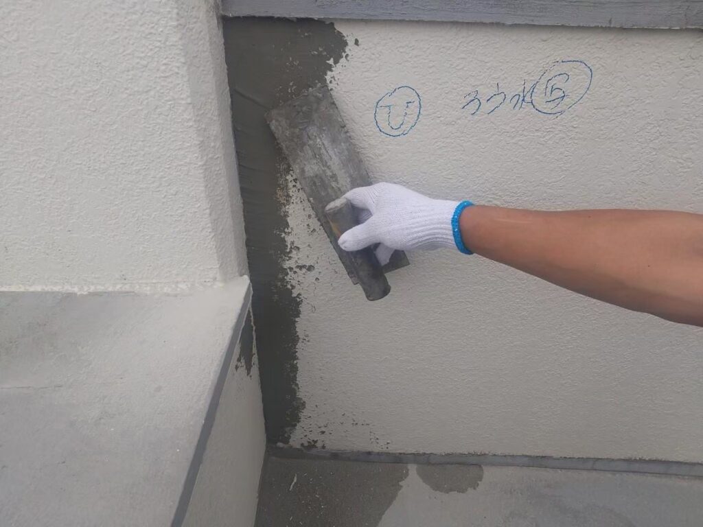 外壁のひび割れにスムースエポを補填した後にモルタルを左官している写真