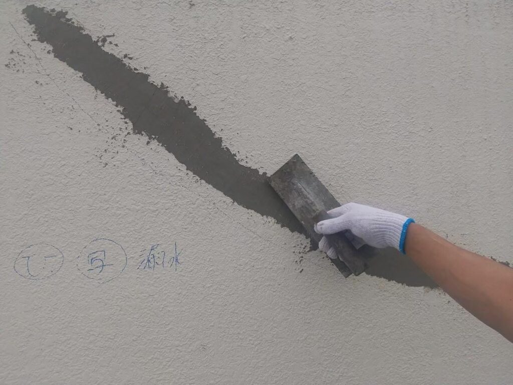 スムースエポを補填した後に外壁のひび割れをモルタルで左官している写真