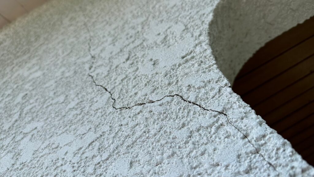 地震の影響により外壁表面にひび割れが発生し、防水性能が低下している状態