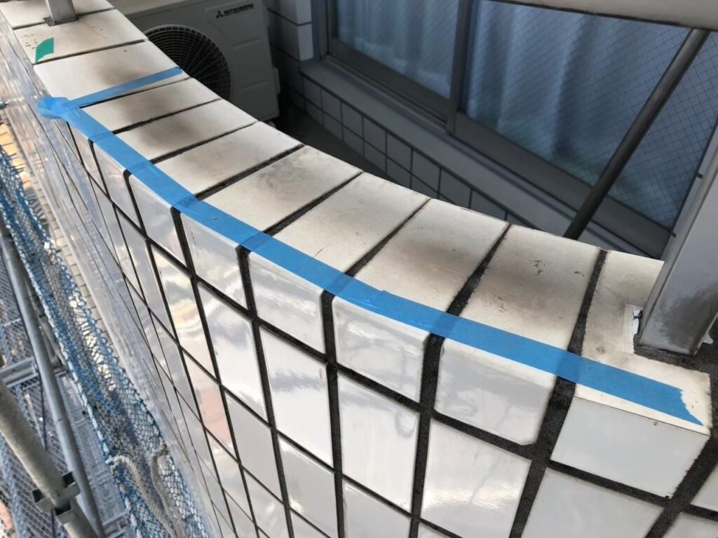 打診棒で外壁タイルを調査してマスキングテープでマーキングした写真