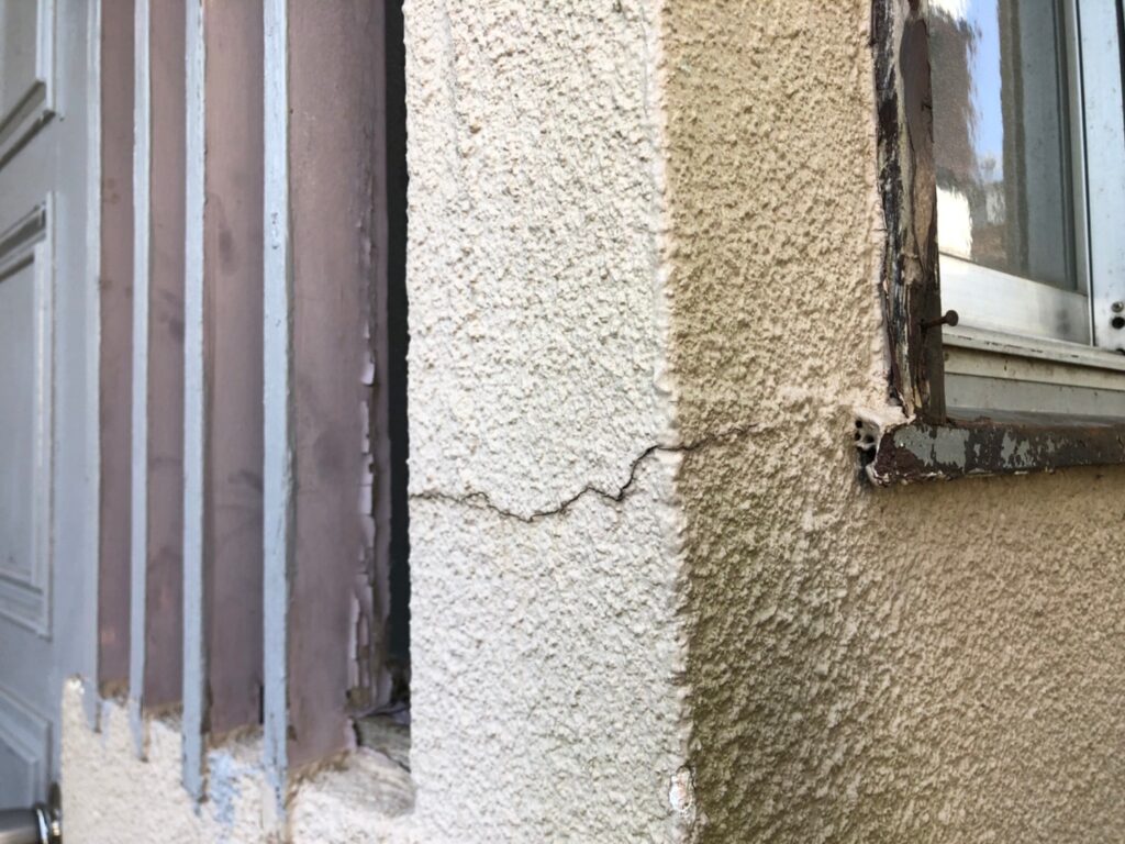 地震の影響により外壁表面にひび割れが発生し、防水性能が低下している状態