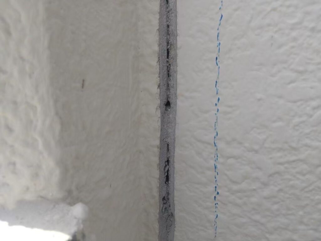 サンダーでVカットした後に、外壁のひび割れの奥に隙間があり、雨漏りの直接的な原因が分かった写真