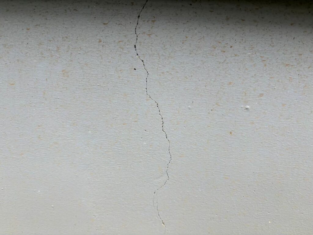 地震の影響により外壁表面にひび割れが発生し、防水性能が低下している状態