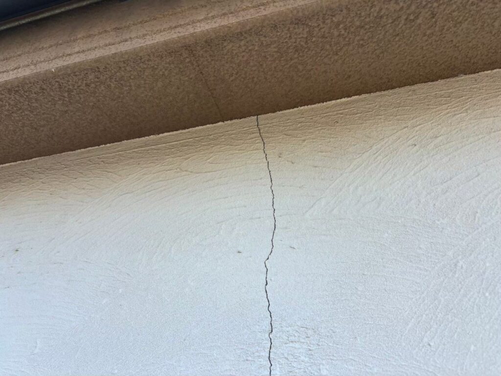 地震の影響により外壁表面にひび割れが発生し、防水性能が低下している状態