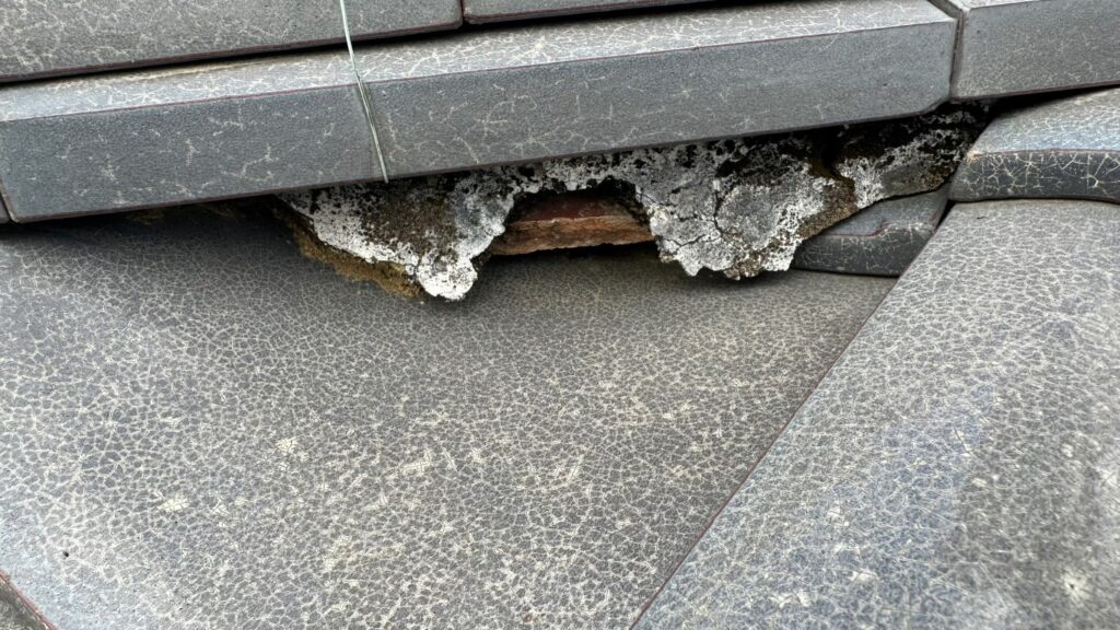 棟部分の漆喰が崩れて飛散し、内部が露出している状態