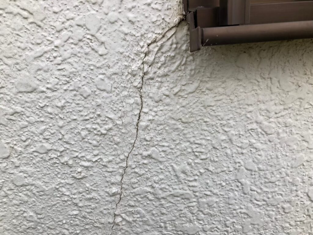 地震の影響により外壁表面にひび割れが発生し、防水性能が低下している状態