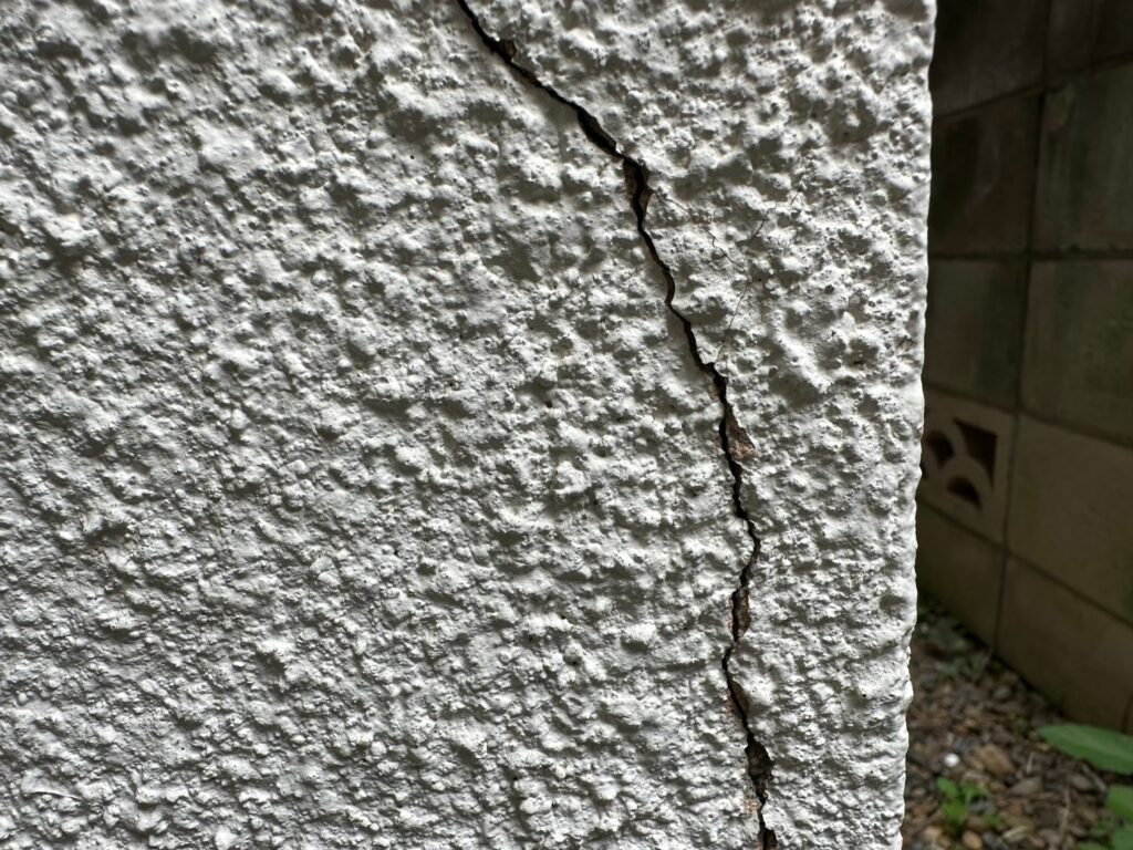 地震の影響により外壁表面にひび割れが発生し、防水性能が低下している状態