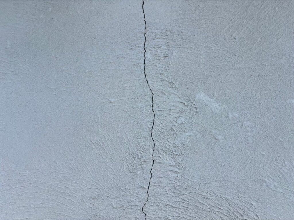 地震の影響により外壁表面にひび割れが発生し、防水性能が低下している状態