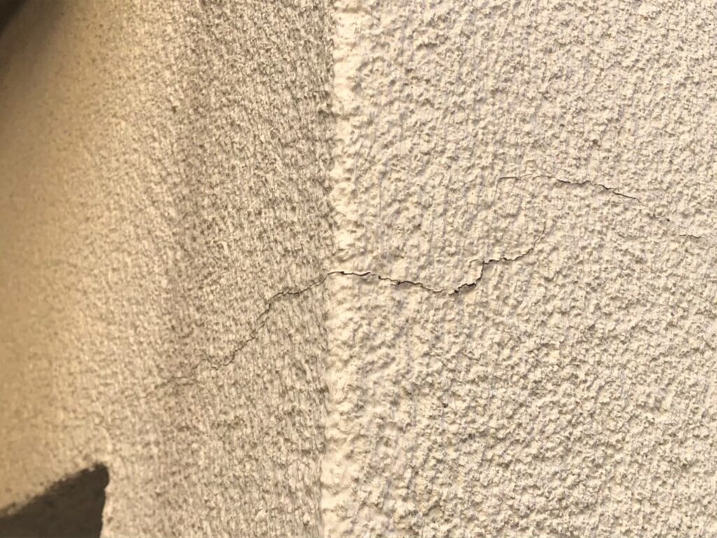 地震の影響により外壁表面にひび割れが発生し、防水性能が低下している状態