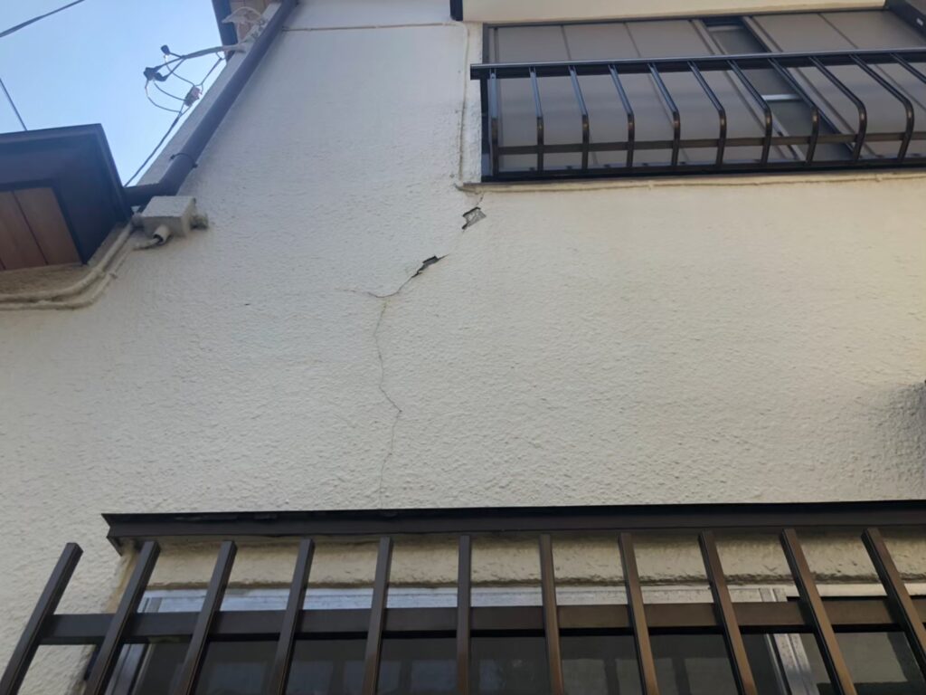 地震の影響により外壁表面にひび割れが発生し、防水性能が低下している状態
