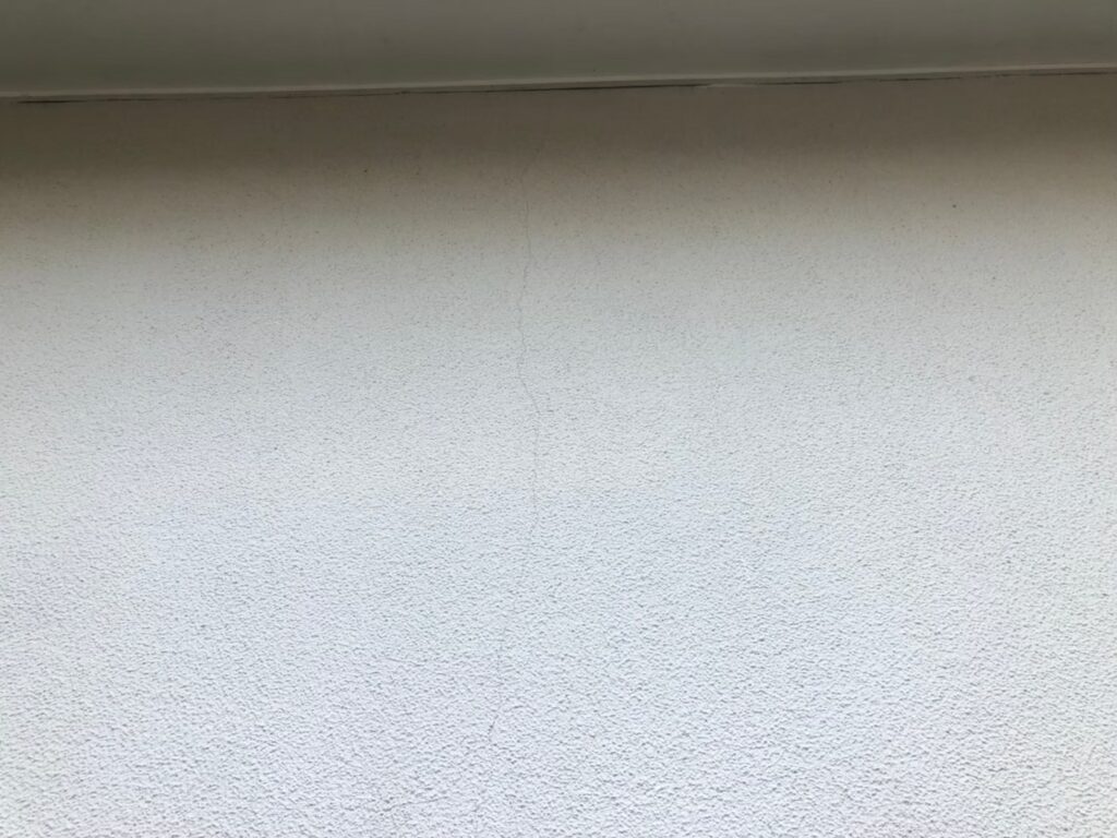 地震の影響により外壁表面にひび割れが発生し、防水性能が低下している状態