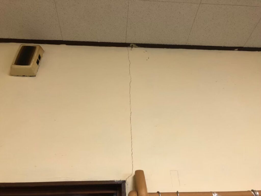 地震の影響により外壁表面にひび割れが発生し、防水性能が低下している状態