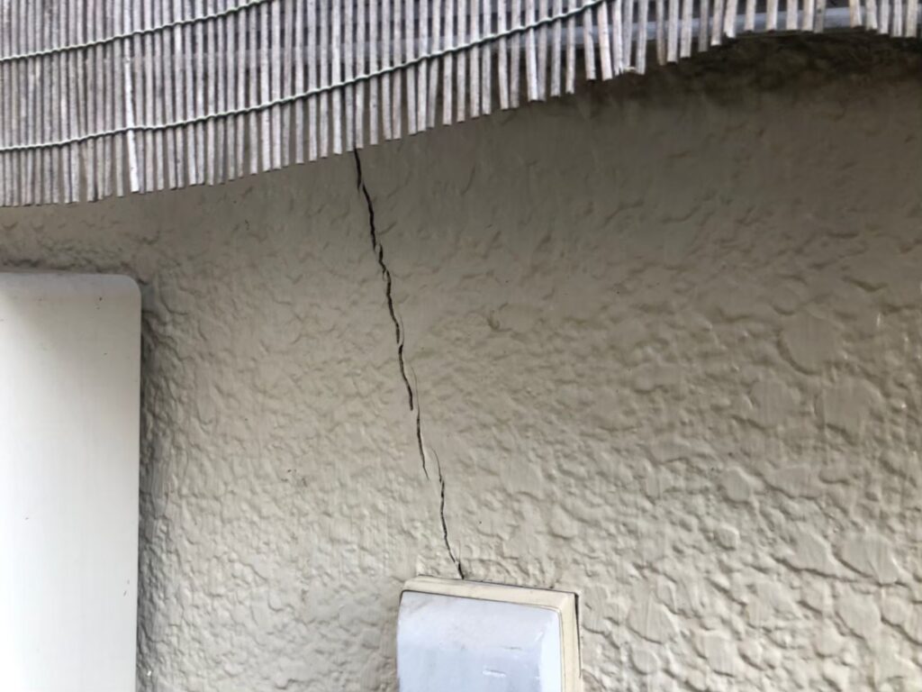 地震の影響により外壁表面にひび割れが発生し、防水性能が低下している状態