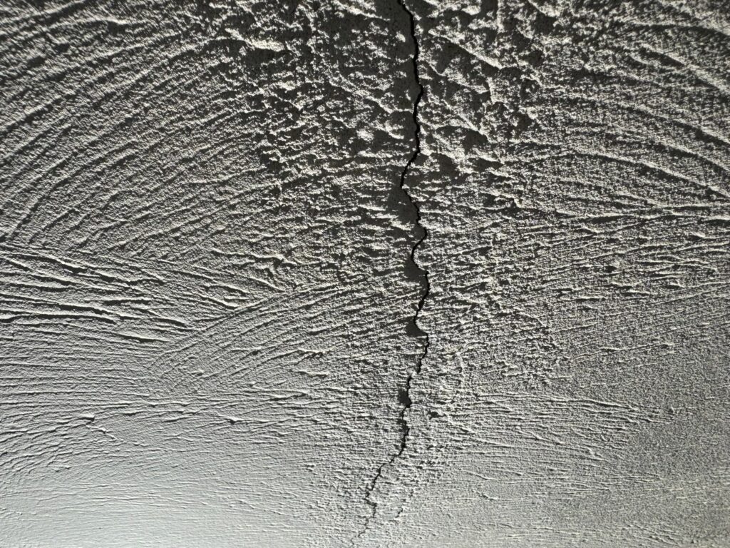 地震の影響により外壁表面にひび割れが発生し、防水性能が低下している状態