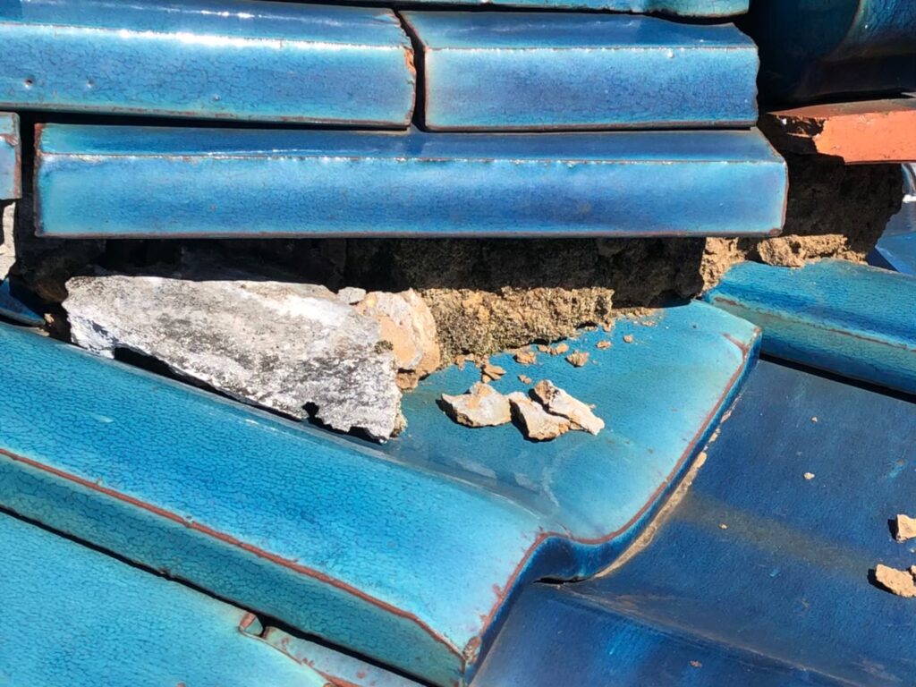 棟部分の漆喰が崩れて飛散し、内部が露出している状態