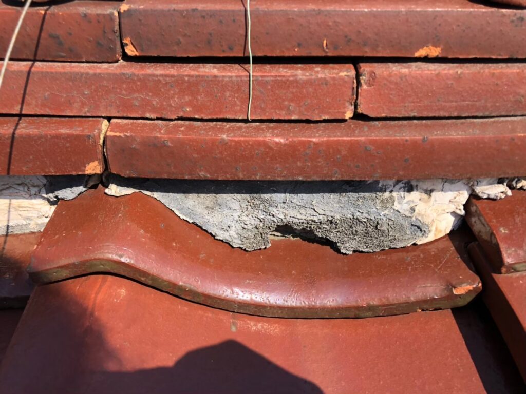 棟部分の漆喰が崩れて飛散し、内部が露出している状態