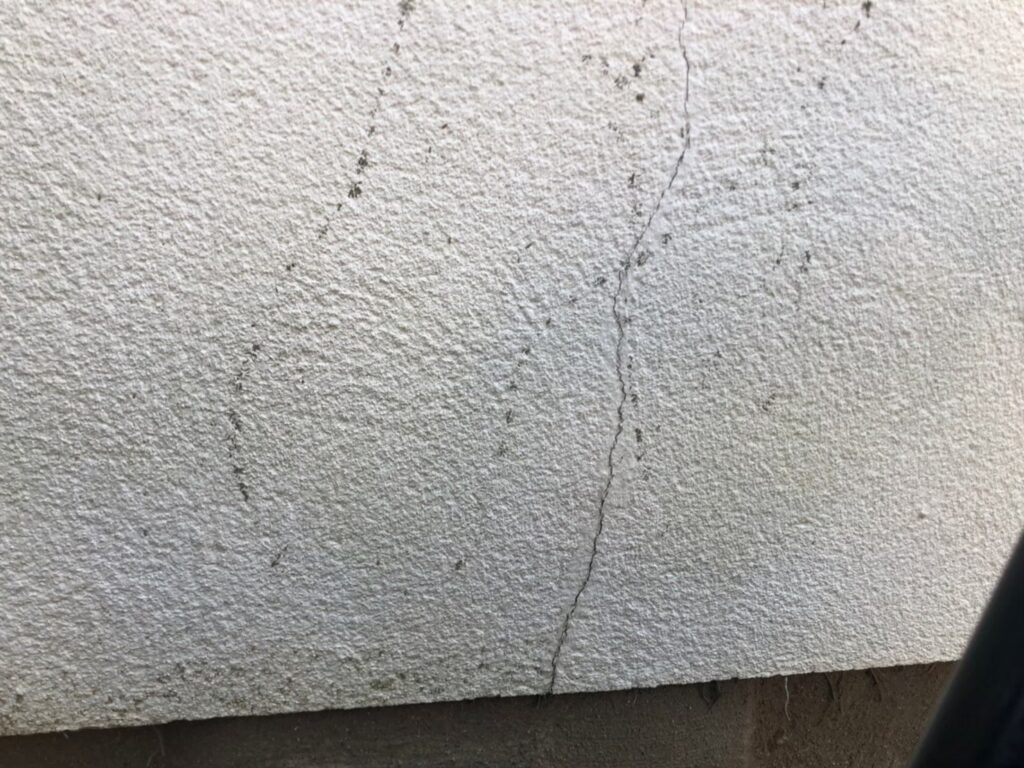 地震の影響により外壁表面にひび割れが発生し、防水性能が低下している状態