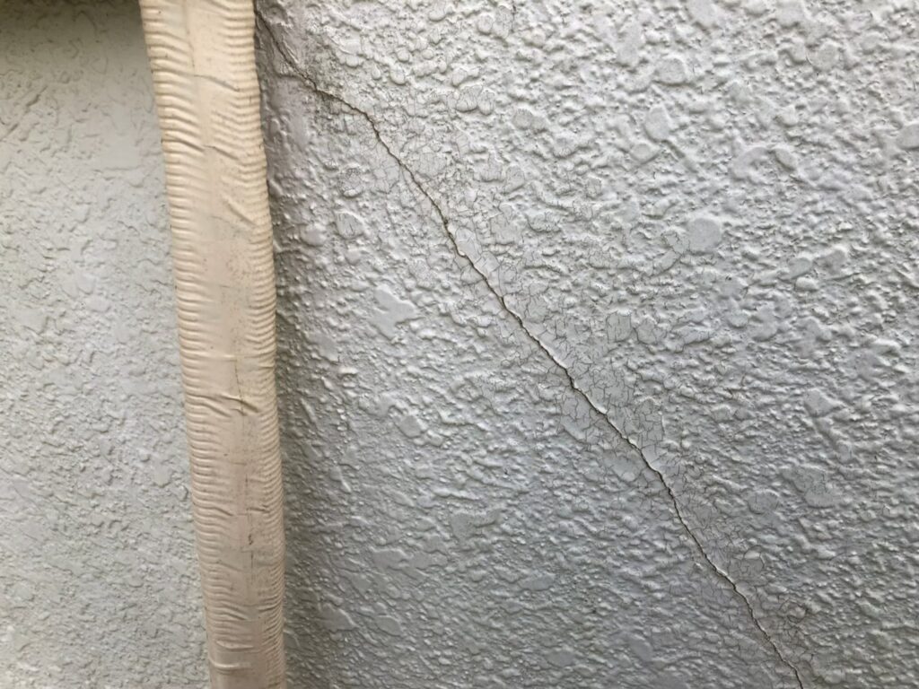 地震の影響により外壁表面にひび割れが発生し、防水性能が低下している状態