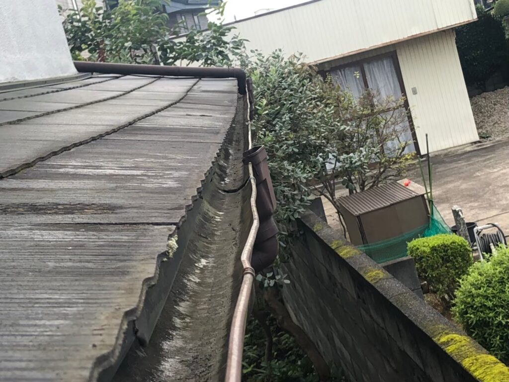 強風の影響により雨樋が大きく歪んでいる状態