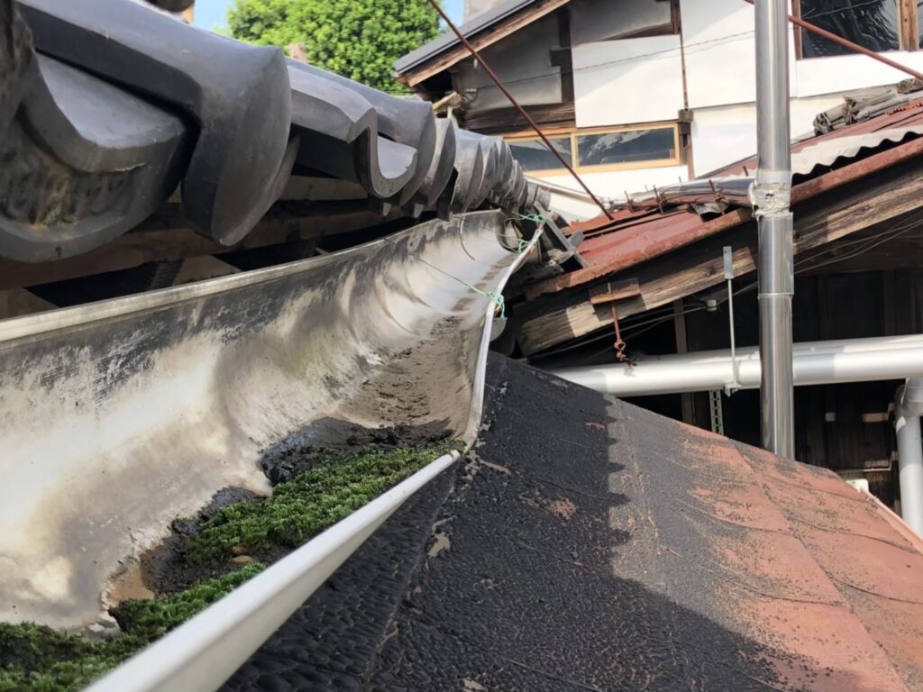 強風の影響により雨樋が大きく歪んでいる状態