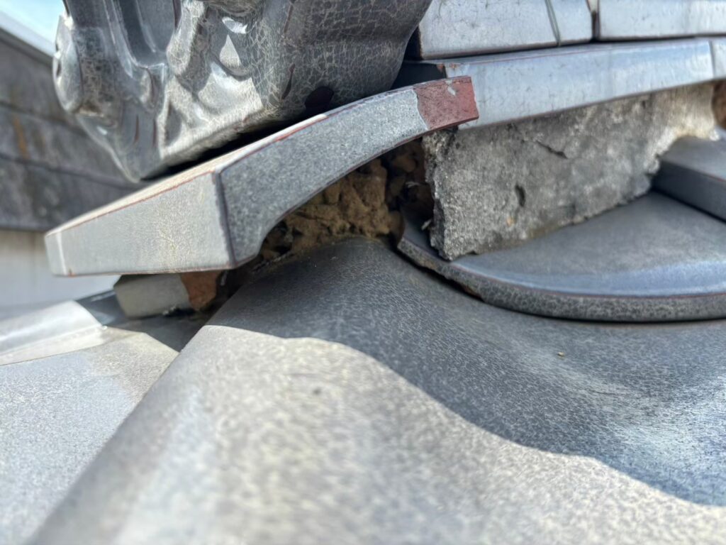 棟部分の漆喰が崩れて飛散し、内部が露出している状態