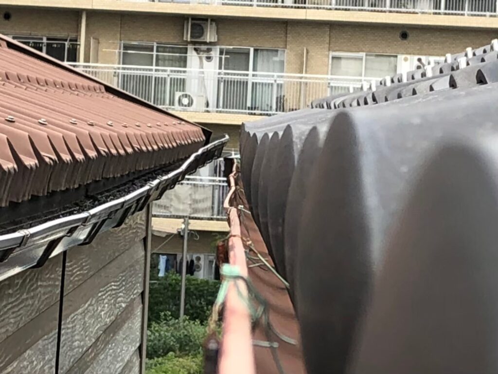 強風の影響により雨樋が大きく歪んでいる状態