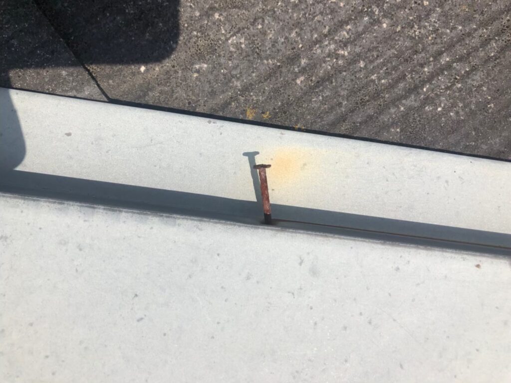 棟板金の釘が経年劣化で浮き、固定力が弱まっている状態