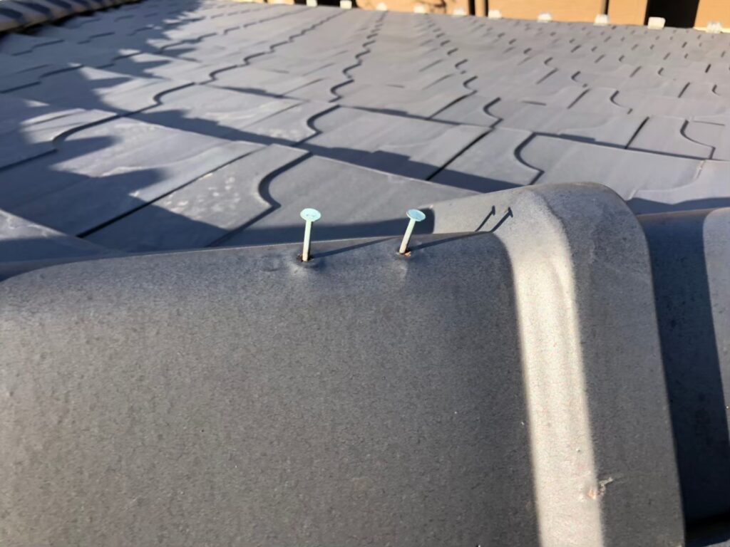 棟板金の釘が経年劣化で浮き、固定力が弱まっている状態