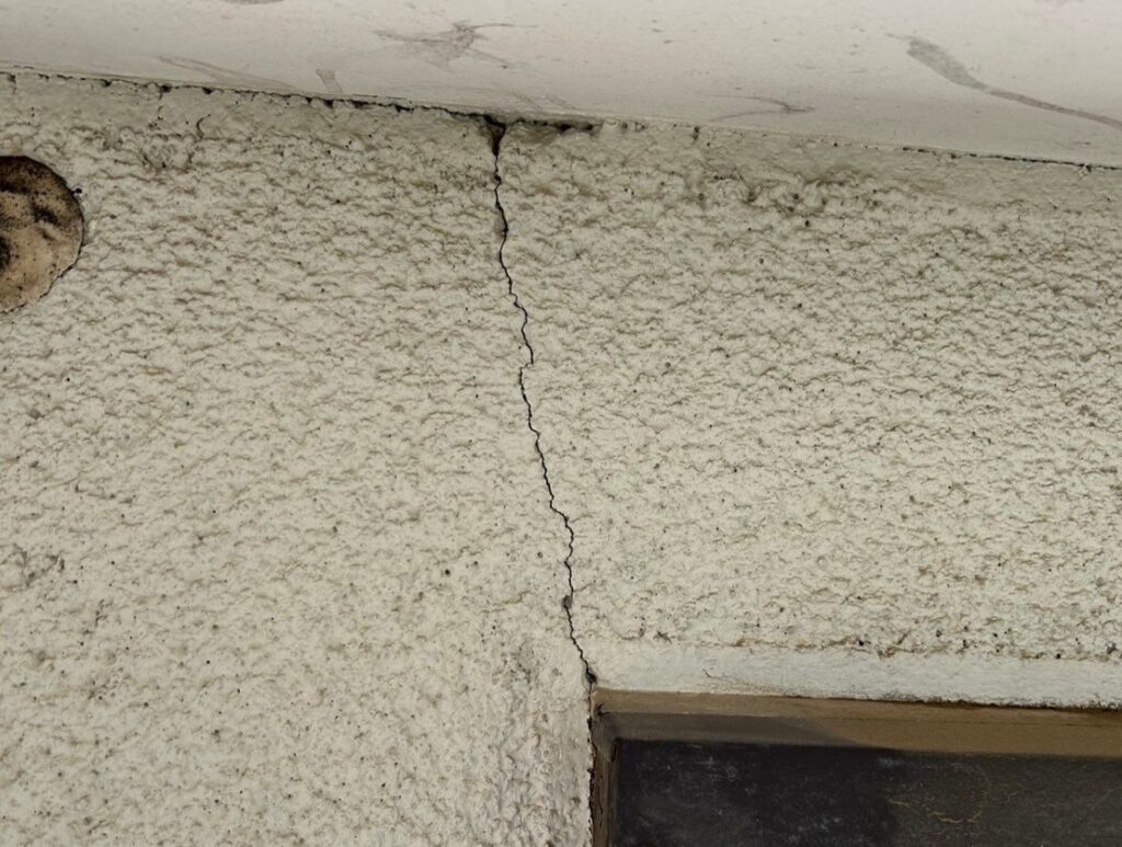 地震の影響により外壁表面がひび割れしている状態
