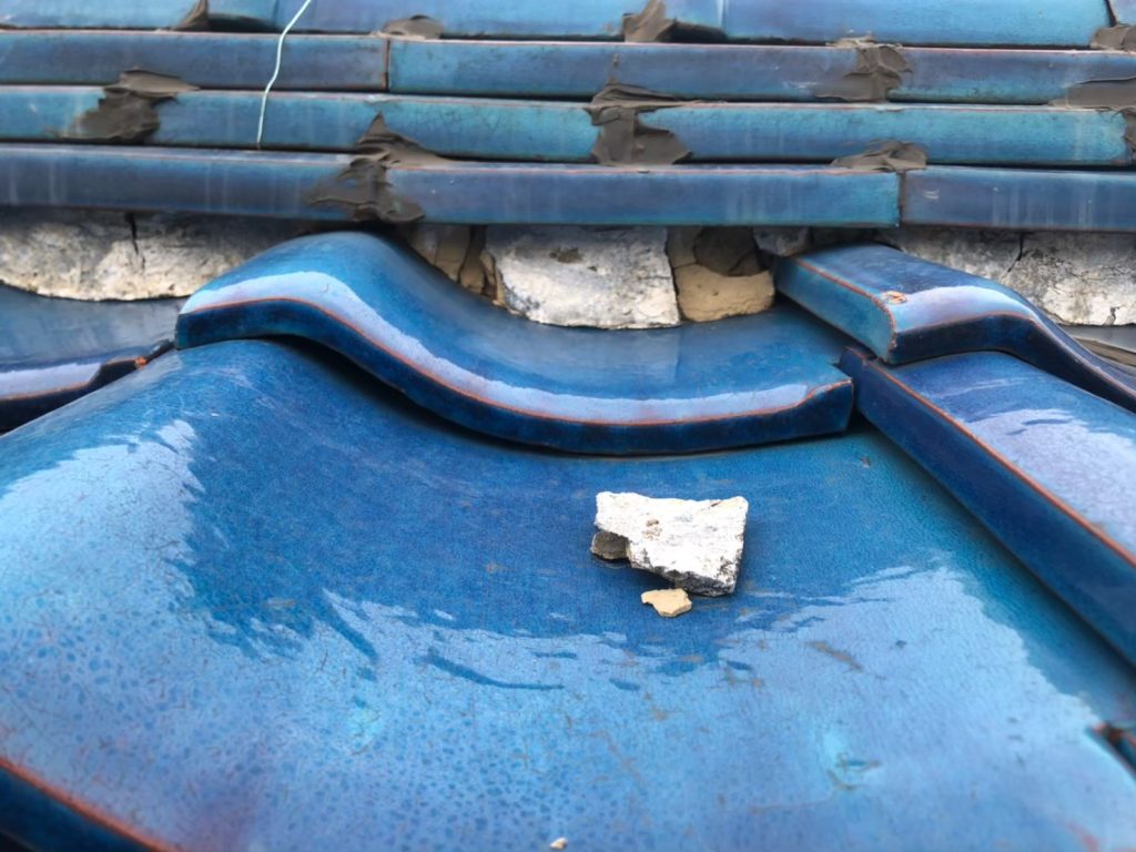 棟部分の漆喰が崩れて飛散し、内部が露出している状態