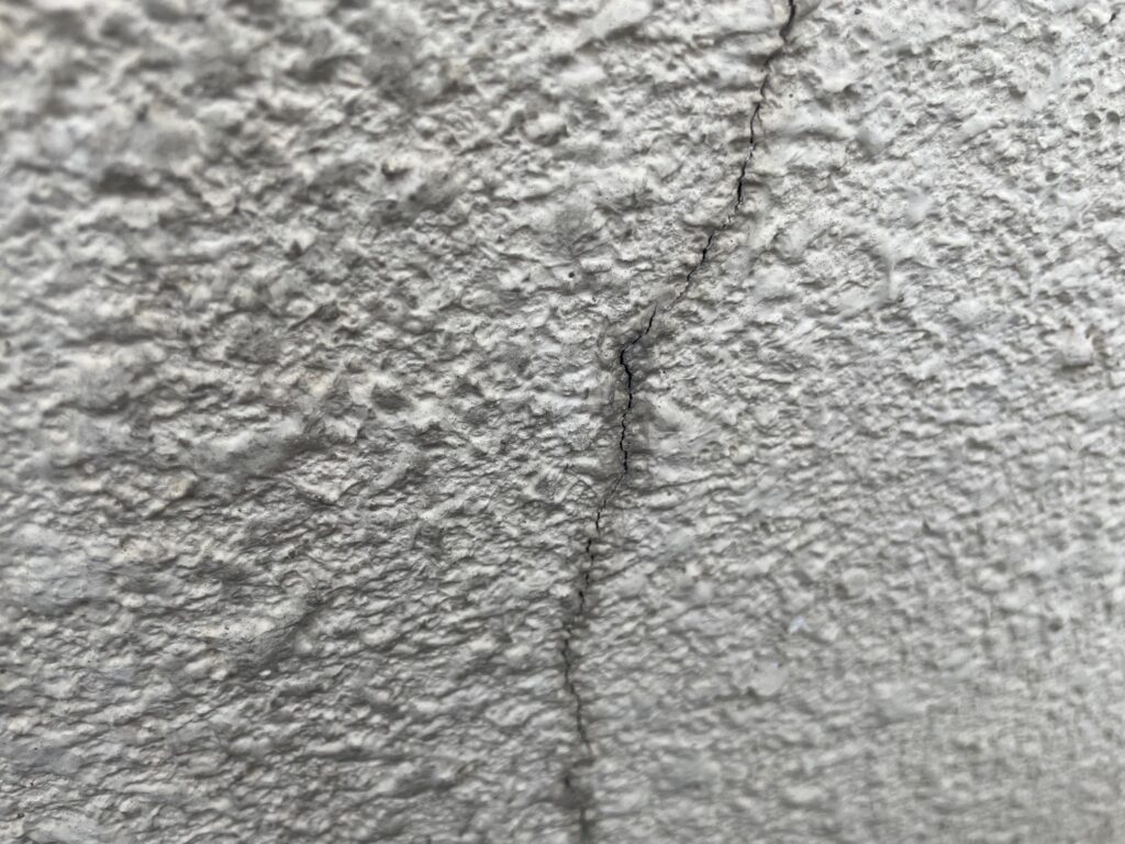 地震の影響により外壁表面にひび割れが発生し、防水性能が低下している状態