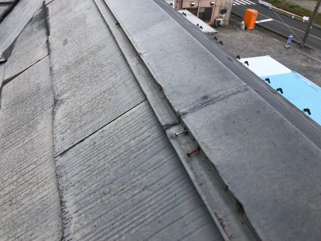 棟板金の釘が経年劣化で浮き、固定力が弱まっている状態