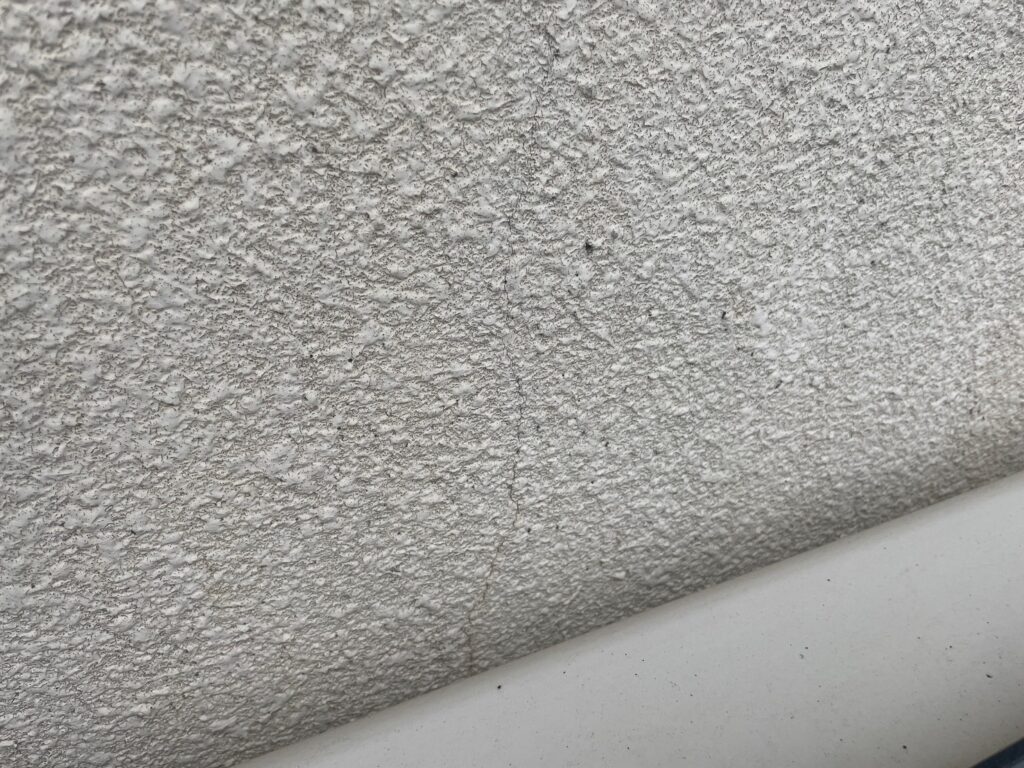 地震の影響により外壁表面にひび割れが発生し、防水性能が低下している状態