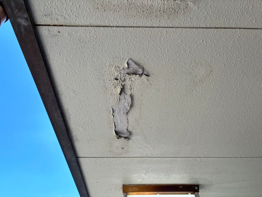 湿気や雨水の影響で軒天が腐食し、剥がれが発生している状態