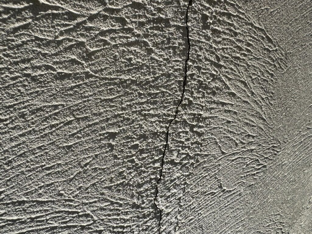 地震の影響により外壁表面がひび割れしている状態