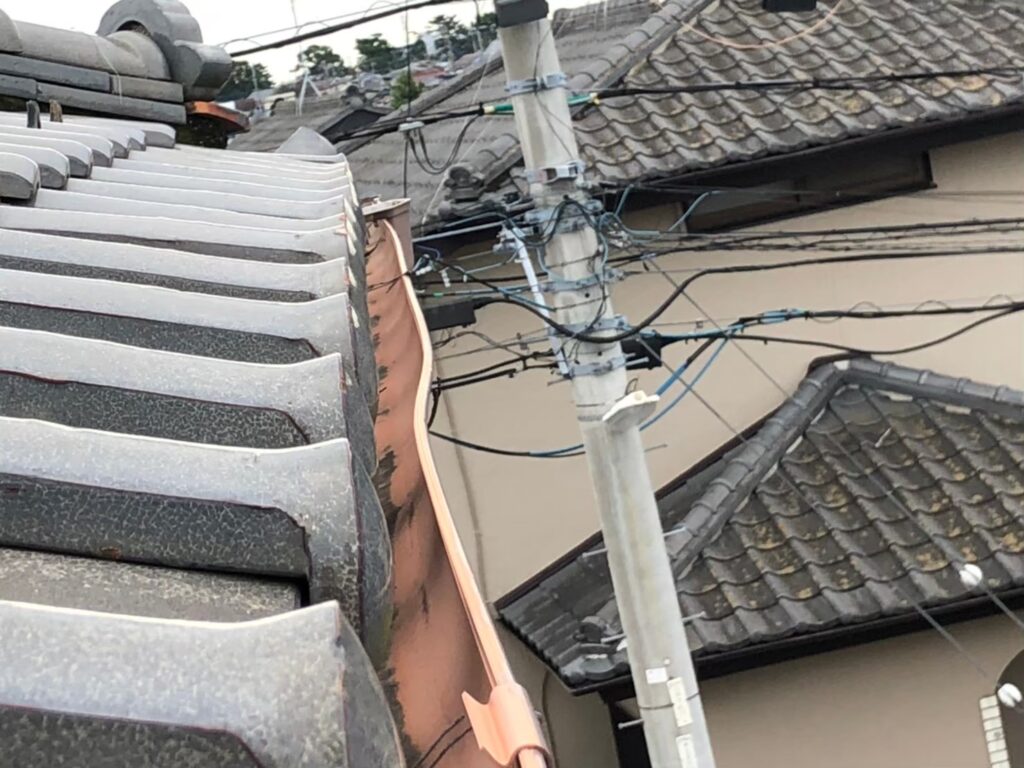 強風の影響により雨樋が大きく歪んでいる状態