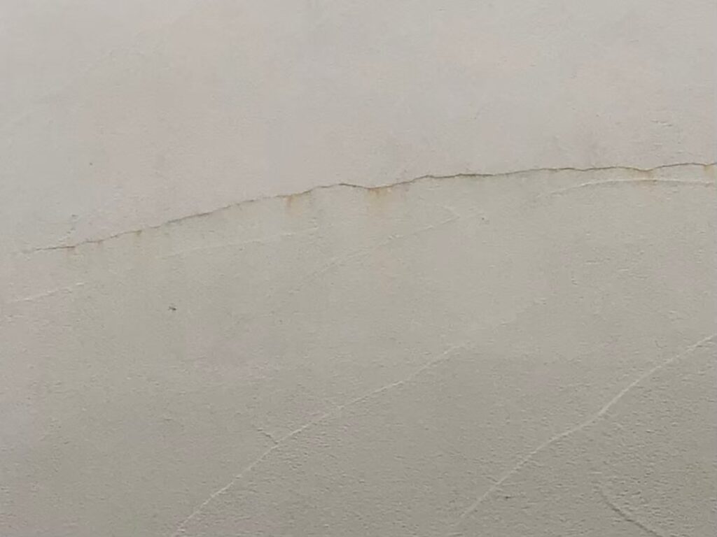 地震の影響により外壁表面がひび割れしている状態