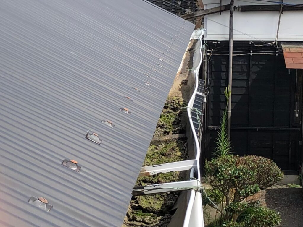 強風の影響により雨樋が大きく歪んでいる状態