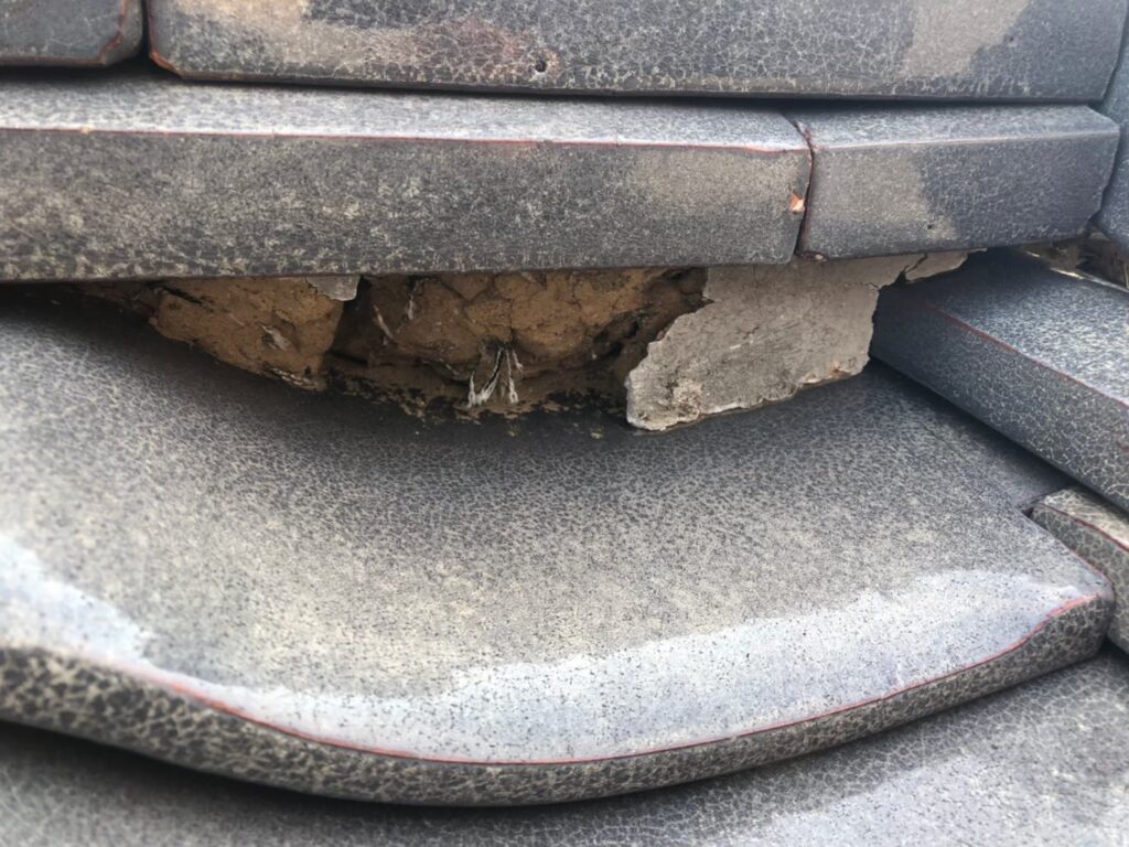 棟部分の漆喰が崩れて飛散し、内部が露出している状態